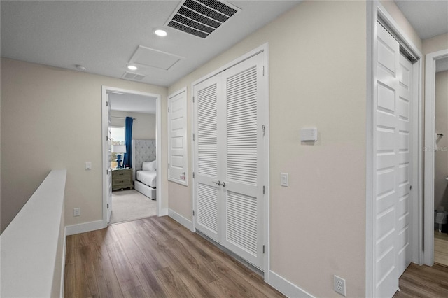 hallway with light hardwood / wood-style floors