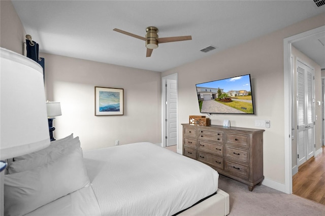 bedroom with ceiling fan, light hardwood / wood-style floors, and a closet