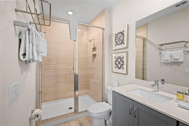 bathroom with vanity, a shower with shower door, and toilet