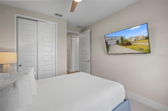 carpeted bedroom featuring ceiling fan and a closet