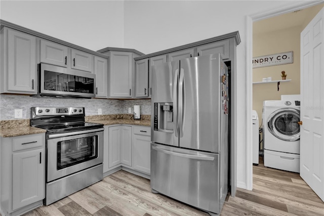 kitchen featuring tasteful backsplash, light hardwood / wood-style flooring, dark stone counters, and stainless steel appliances