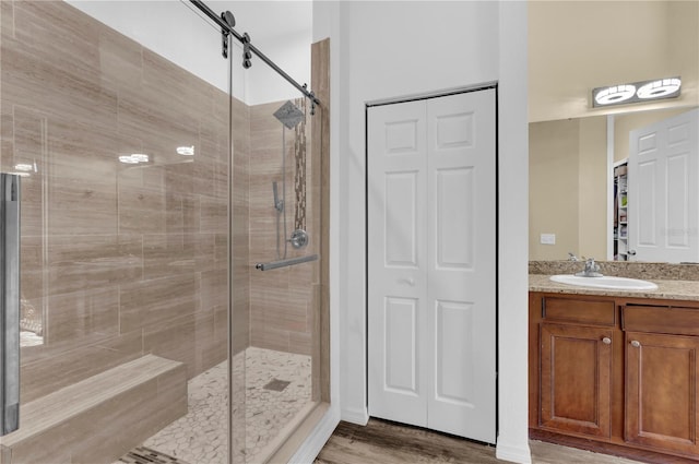 bathroom featuring wood-type flooring, vanity, and a shower with door