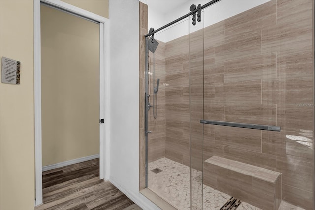 bathroom with hardwood / wood-style flooring and a shower with shower door