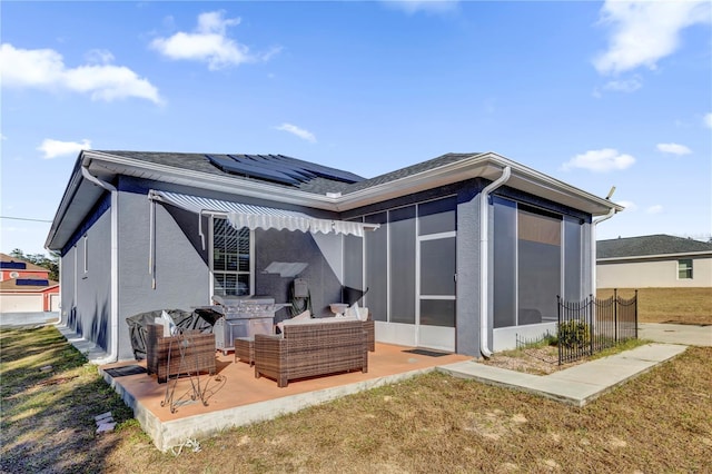 back of house with a lawn, solar panels, an outdoor living space, and a patio