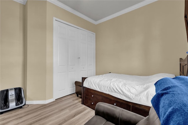 bedroom featuring a closet, crown molding, and light hardwood / wood-style flooring