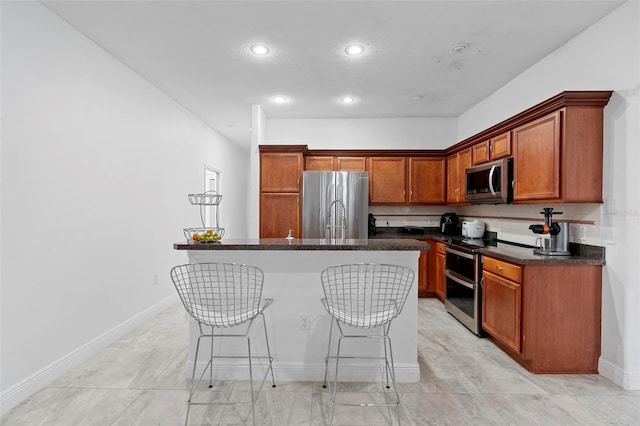 kitchen featuring appliances with stainless steel finishes, a center island, and a kitchen breakfast bar
