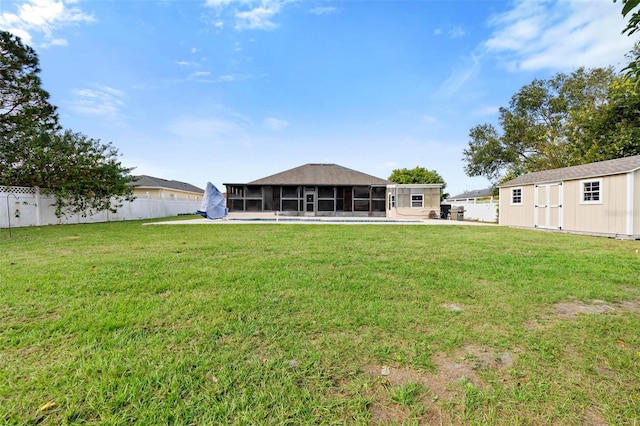 back of property with a yard, a shed, and a sunroom