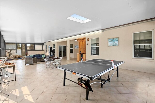 game room featuring light tile patterned floors and a skylight