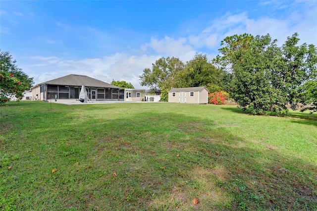 view of yard featuring a sunroom and a storage shed