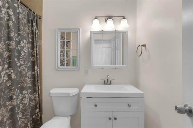 bathroom with a shower with shower curtain, vanity, and toilet