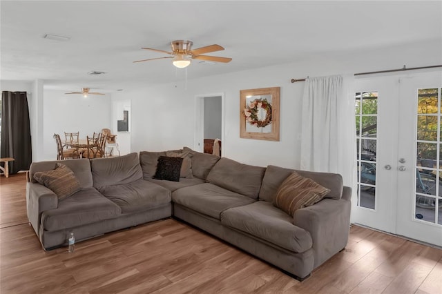 living room with ceiling fan, french doors, and wood-type flooring