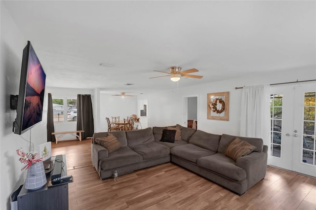 living room featuring french doors, ceiling fan, and wood-type flooring