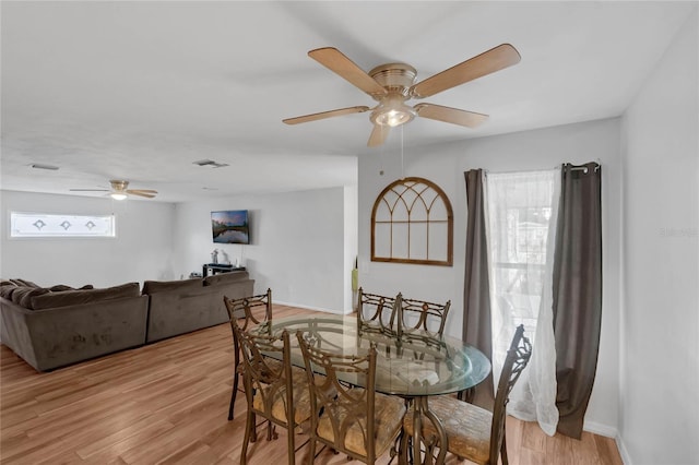 dining space with light wood-type flooring and ceiling fan