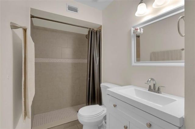 bathroom with a shower with curtain, vanity, toilet, and tile patterned floors