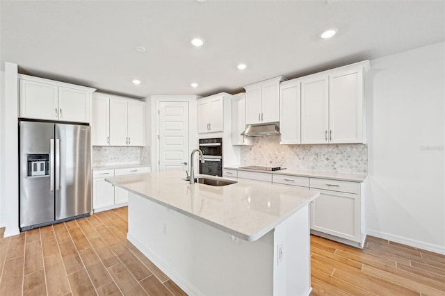 kitchen with sink, white cabinets, tasteful backsplash, black appliances, and a kitchen island with sink