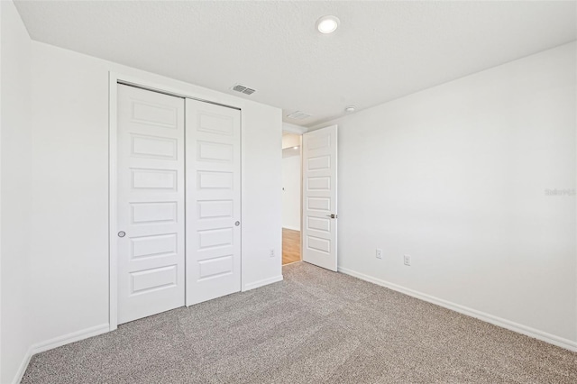 unfurnished bedroom with a closet and carpet floors