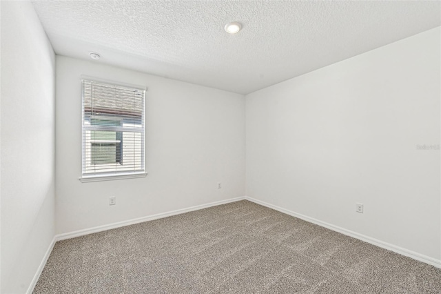 carpeted spare room with a textured ceiling