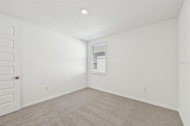 spare room with a textured ceiling and carpet