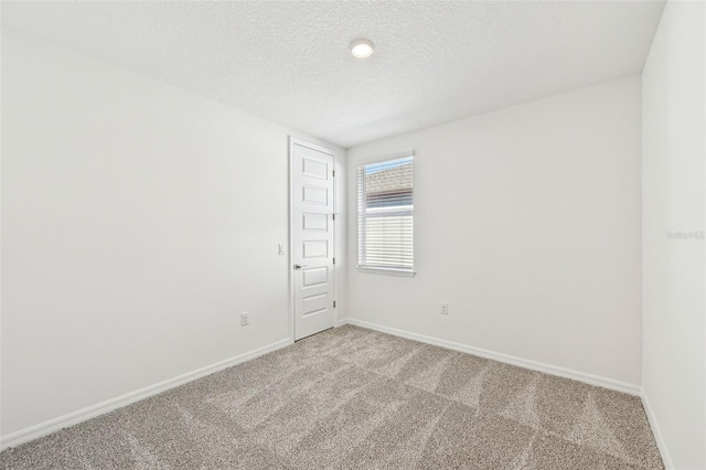 carpeted spare room featuring a textured ceiling