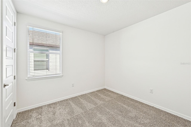 carpeted empty room featuring a textured ceiling