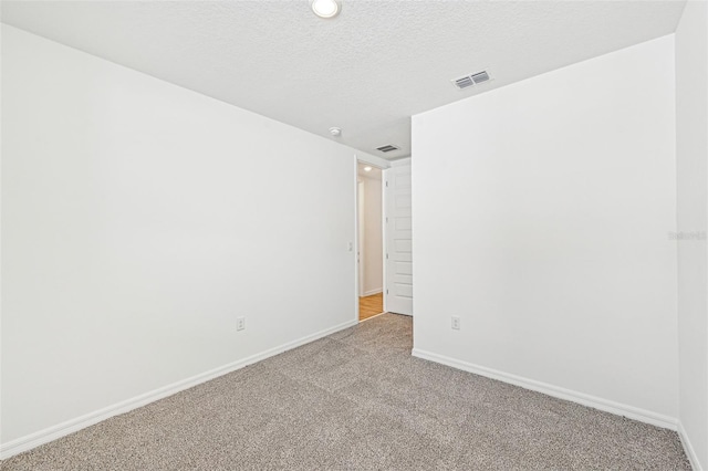 carpeted spare room featuring a textured ceiling