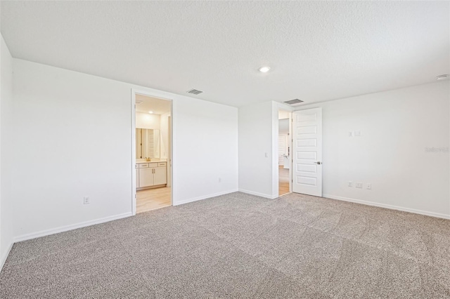 interior space featuring a textured ceiling and light carpet