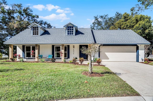 view of front facade with a garage, covered porch, and a front lawn