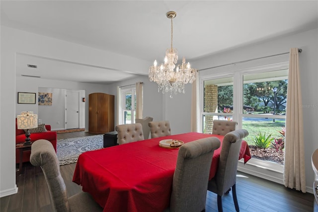 dining area with dark hardwood / wood-style flooring and a notable chandelier