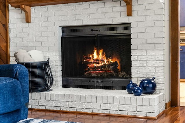 room details with wood-type flooring and a brick fireplace