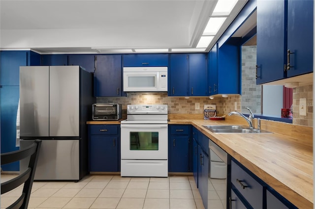 kitchen with sink, blue cabinets, butcher block countertops, white appliances, and light tile patterned floors