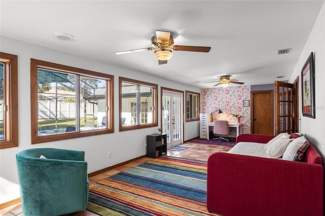 tiled living room featuring ceiling fan and french doors