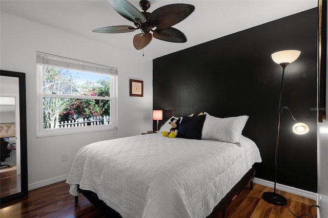 bedroom with dark hardwood / wood-style flooring and ceiling fan