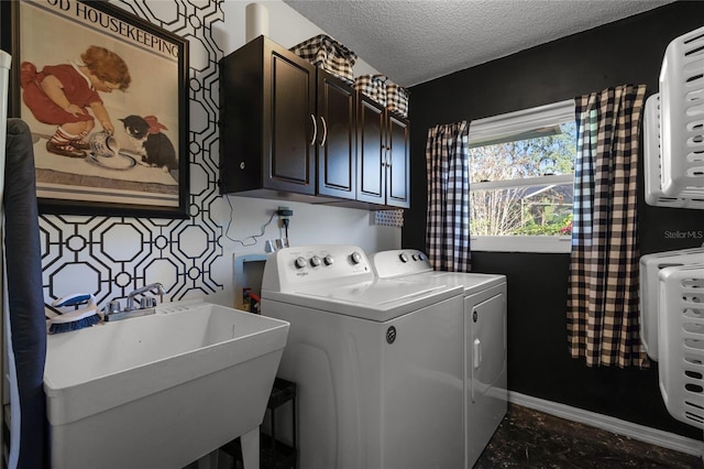 washroom with cabinets, a textured ceiling, washer and dryer, and sink