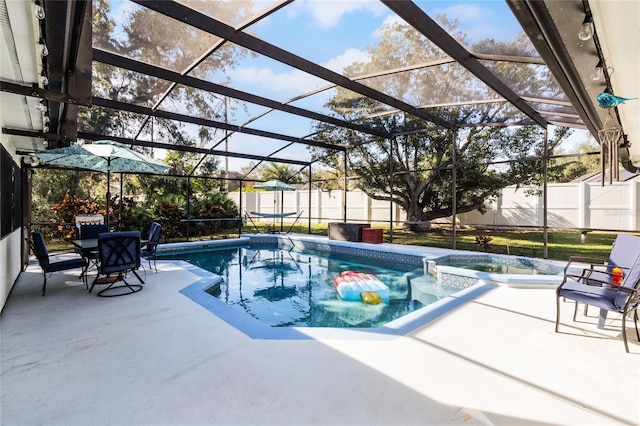 view of pool with glass enclosure, an in ground hot tub, and a patio area