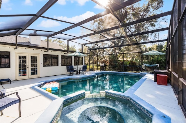 view of pool with glass enclosure, a patio area, an in ground hot tub, and french doors