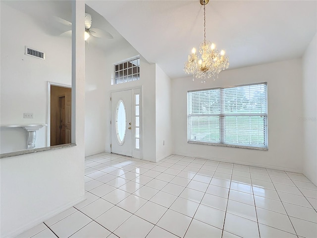 tiled entrance foyer with ceiling fan with notable chandelier and a wealth of natural light