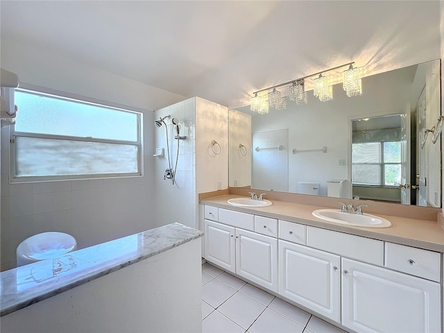 bathroom featuring tile patterned flooring, vanity, toilet, and a tile shower