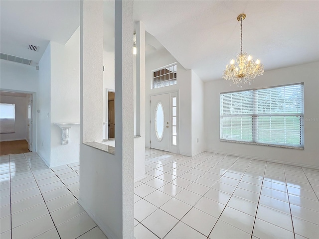 tiled entrance foyer with a notable chandelier