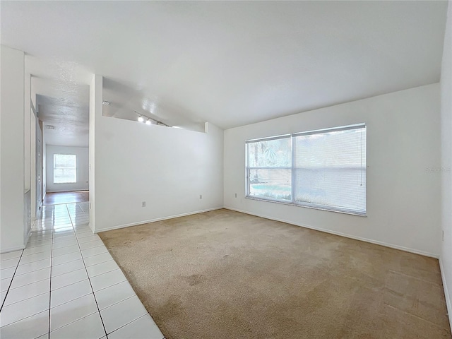 unfurnished room featuring light colored carpet and vaulted ceiling