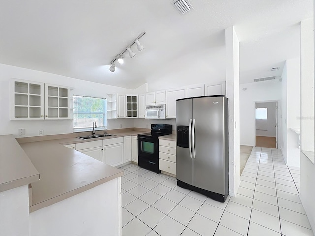 kitchen featuring black electric range oven, sink, stainless steel fridge, white cabinetry, and light tile patterned flooring