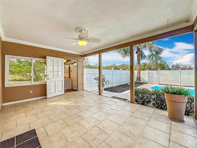 unfurnished sunroom with ceiling fan