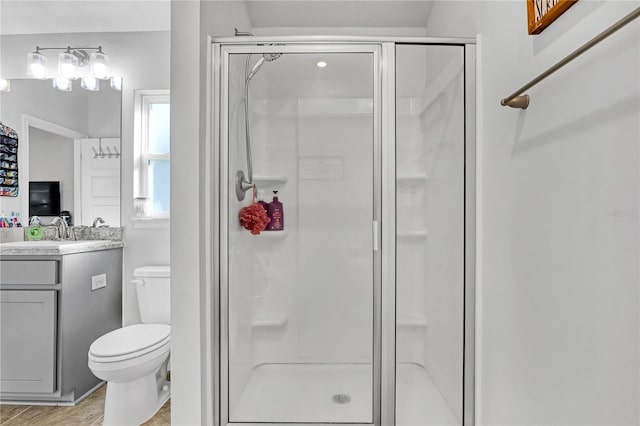 bathroom featuring toilet, vanity, and walk in shower