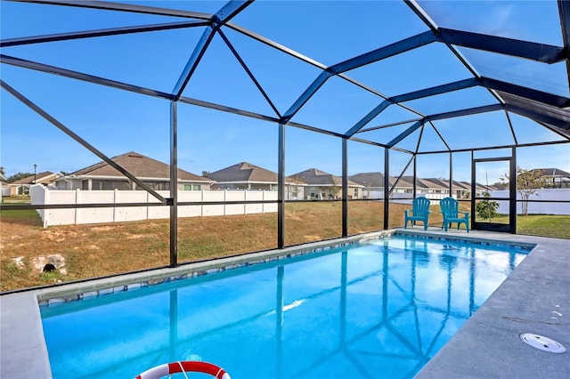 view of swimming pool featuring a lanai and a lawn