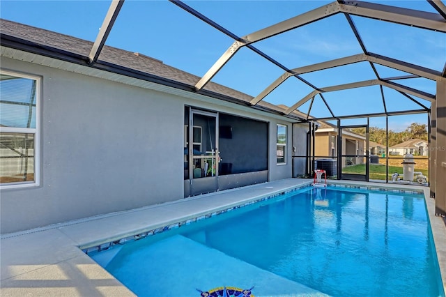 view of swimming pool with a patio, glass enclosure, and central AC unit