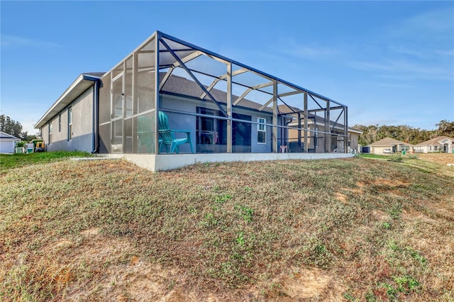 back of property featuring a lawn and a lanai