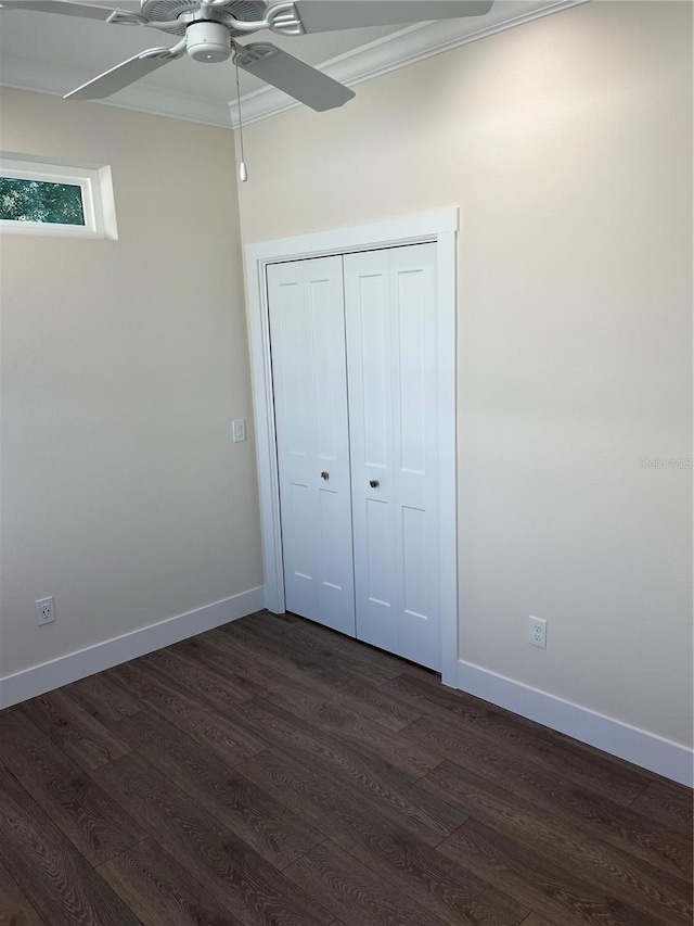 unfurnished bedroom with dark hardwood / wood-style flooring, a closet, ceiling fan, and ornamental molding