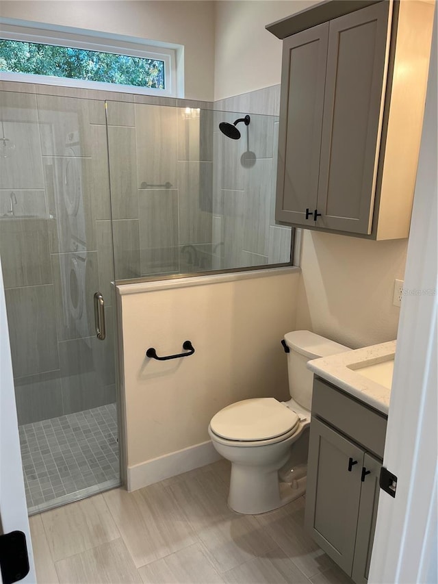 bathroom featuring toilet, vanity, and walk in shower