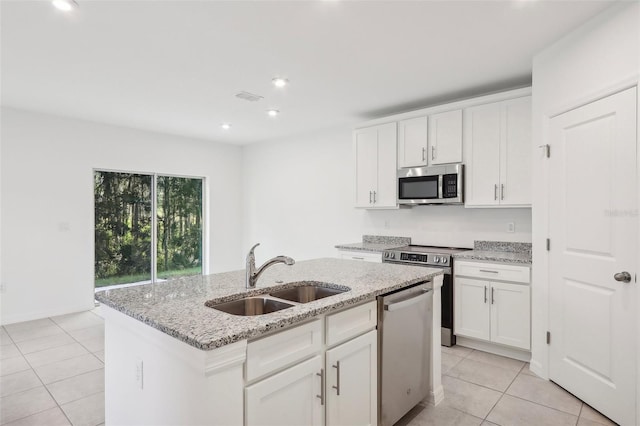 kitchen with appliances with stainless steel finishes, a center island with sink, white cabinetry, and sink