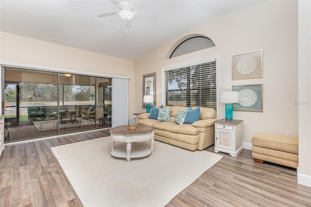 living room with ceiling fan, vaulted ceiling, and hardwood / wood-style flooring