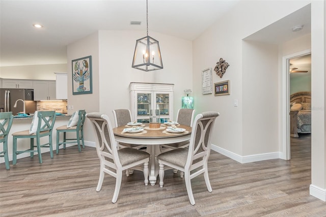 dining room featuring light hardwood / wood-style flooring and lofted ceiling